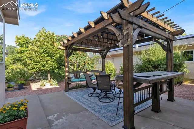 a roof deck with table and chairs and potted plants