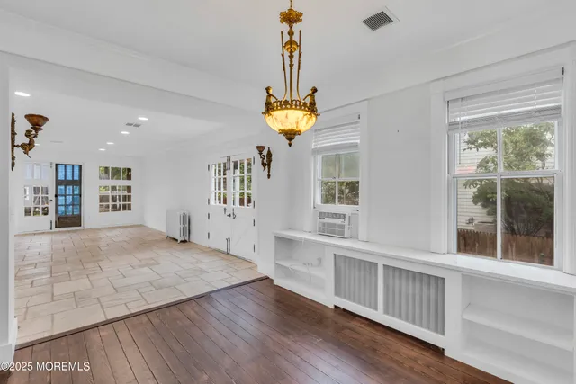 a hallway with wooden floor and windows