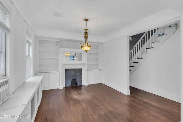 a view of a livingroom with wooden floor and a ceiling fan