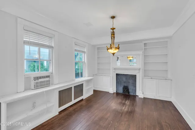 a view of an empty room with a window and fireplace