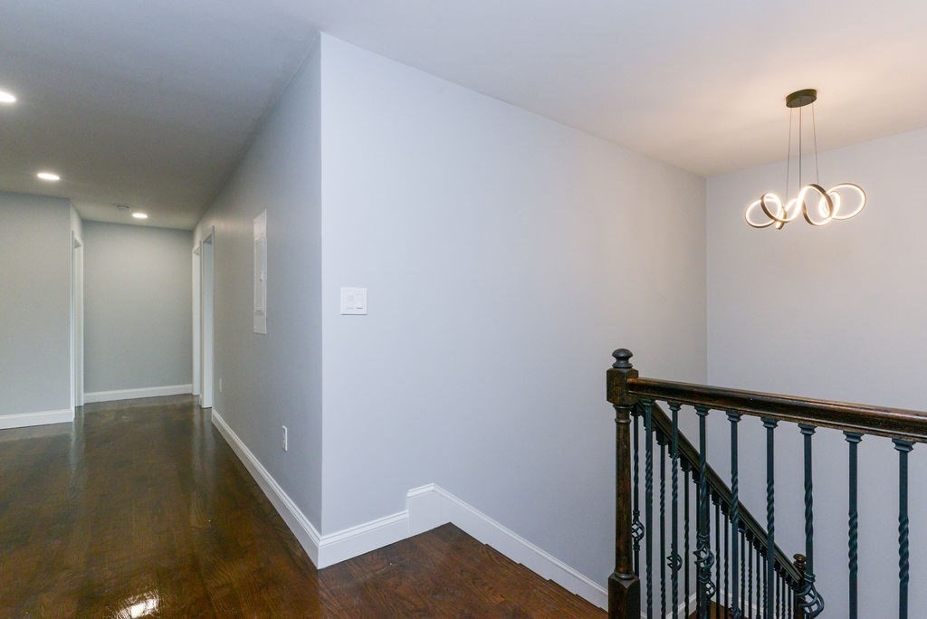 79 Holmes Road Dedham, MA 02026 - Photo 18 of 42 a view of a hallway view with wooden floor and a chandelier