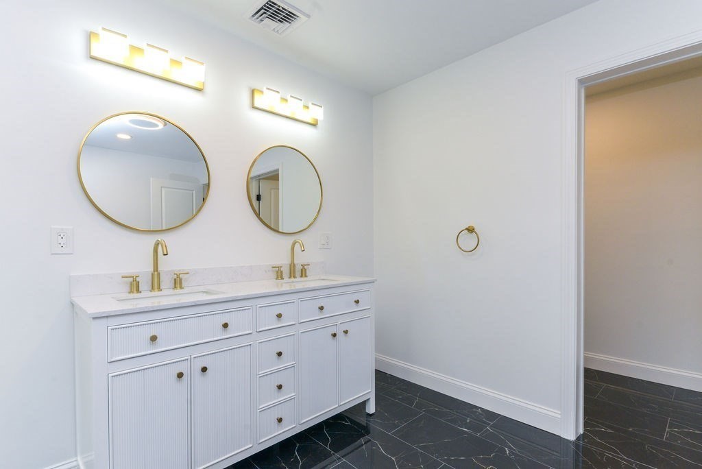79 Holmes Road Dedham, MA 02026 - Photo 28 of 42 a bathroom with a double vanity sink and a mirror