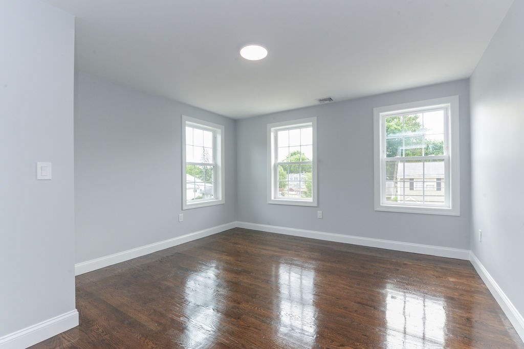79 Holmes Road Dedham, MA 02026 - Photo 34 of 42 a view of an empty room with wooden floor and a window