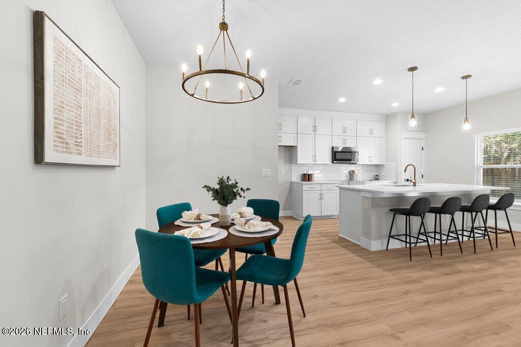 9019 Hipps Road Jacksonville, FL 32222 - Photo 13 of 35 a view of a dining room with furniture and wooden floor