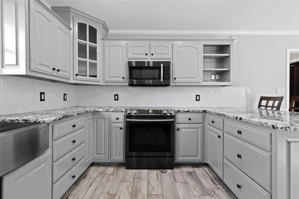 a kitchen with stainless steel appliances granite countertop a stove and cabinets