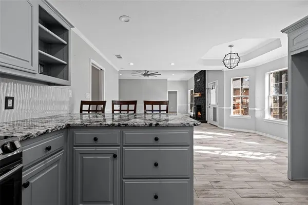 a kitchen with granite countertop a sink and cabinets