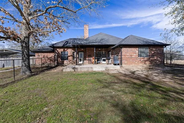 a backyard of a house with barbeque oven table and chairs