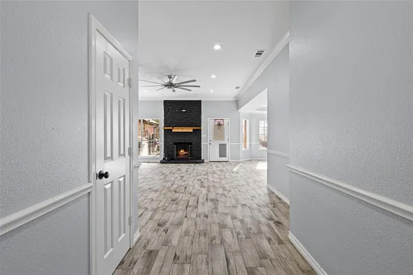 a view of empty room with a fireplace and wooden floor
