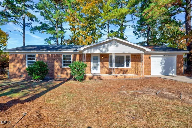 a front view of a house with yard patio and outdoor seating