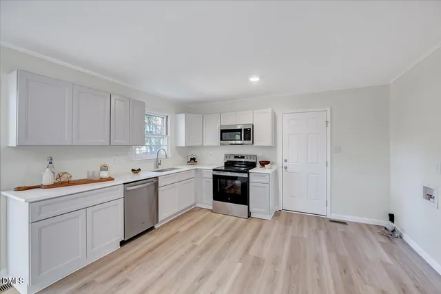a kitchen with stove cabinets and wooden floor