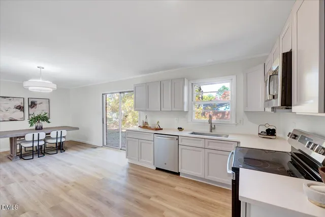 a kitchen with a stove a sink and a window