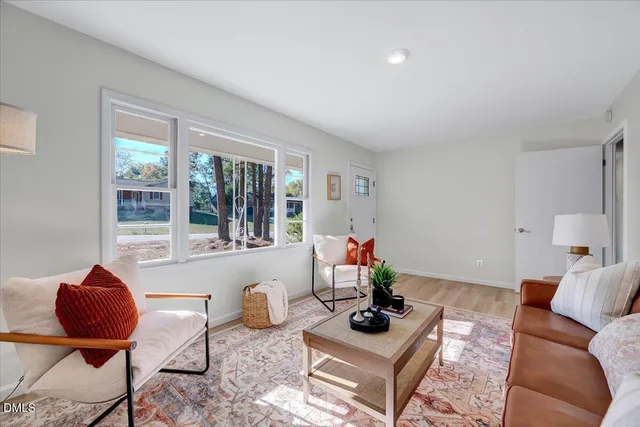 a living room with furniture a rug and a large window