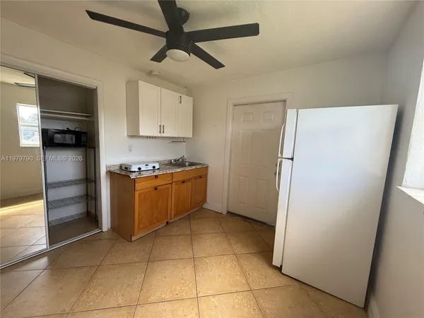 a kitchen with granite countertop a refrigerator and a stove top oven