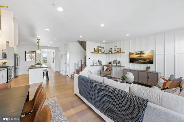 a living room with furniture and a view of kitchen