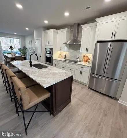 a kitchen with stainless steel appliances granite countertop a table chairs refrigerator sink and microwave