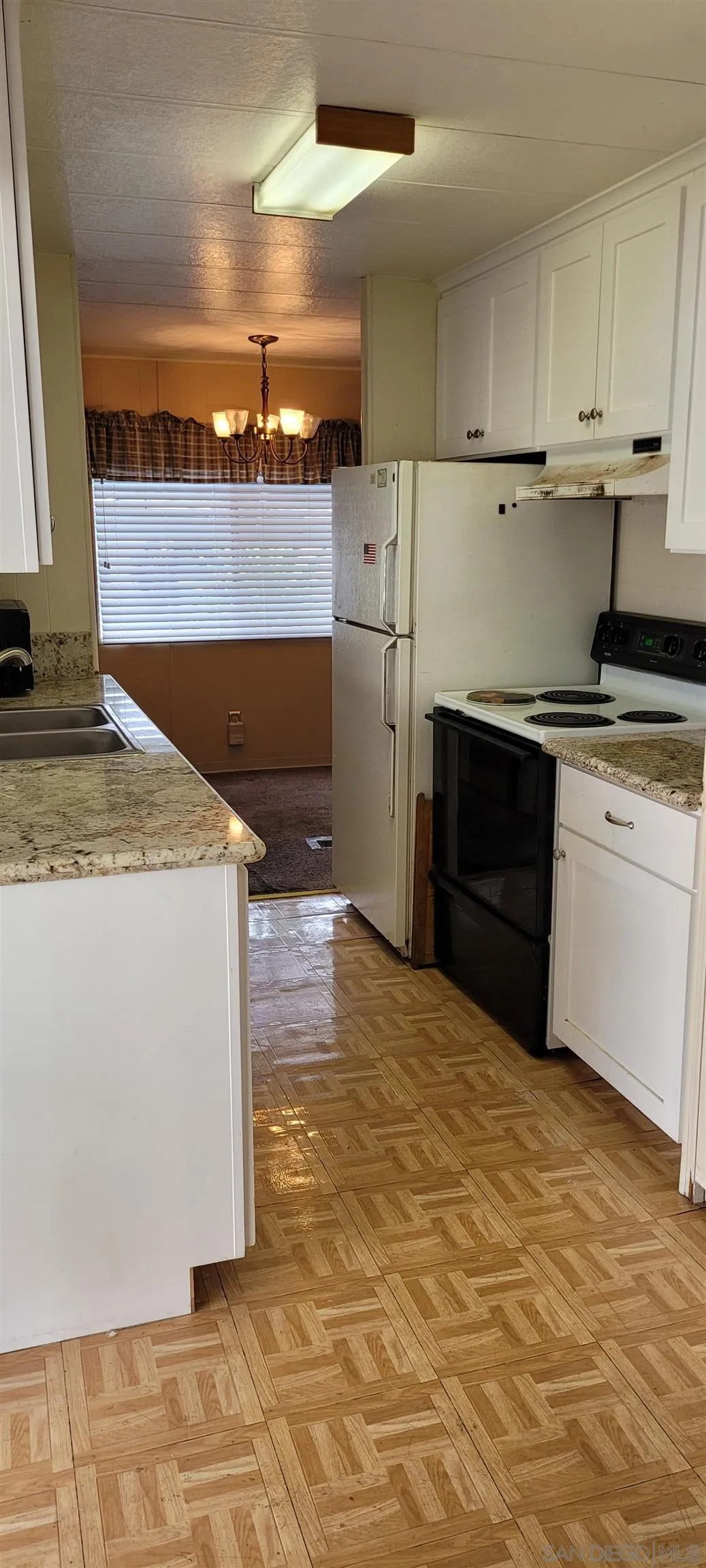 14004 Jasmine Avenue, Unit 260 Poway, CA 92064 - Photo 4 of 6 a kitchen with a sink stove and cabinets