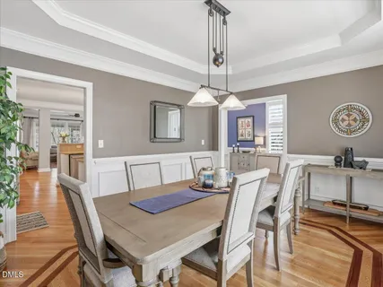 a kitchen with stainless steel appliances kitchen island granite countertop a table chairs refrigerator and microwave