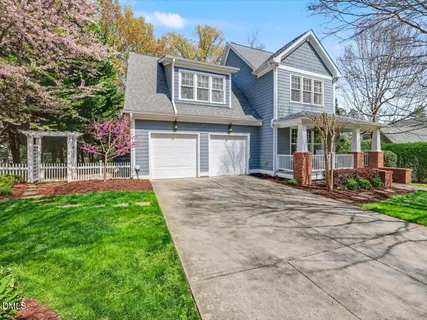 a front view of a house with a yard and trees