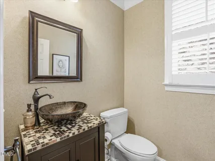 a bathroom with a granite countertop sink a toilet and mirror