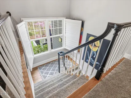 a view of a backyard with potted plants and large trees