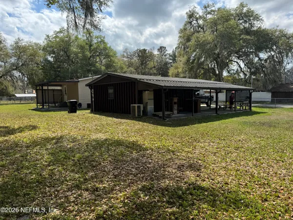 a view of a house with a yard and sitting area