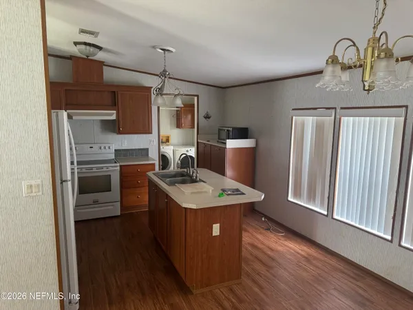 a kitchen with stainless steel appliances granite countertop a sink a stove and a refrigerator