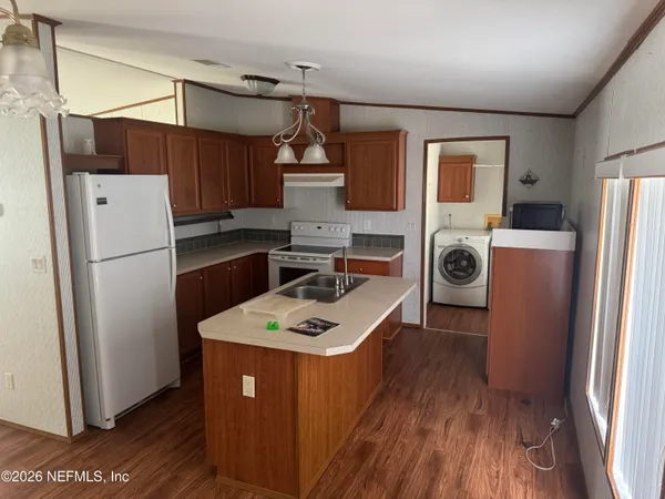 a kitchen with a refrigerator a stove top oven a refrigerator and a window