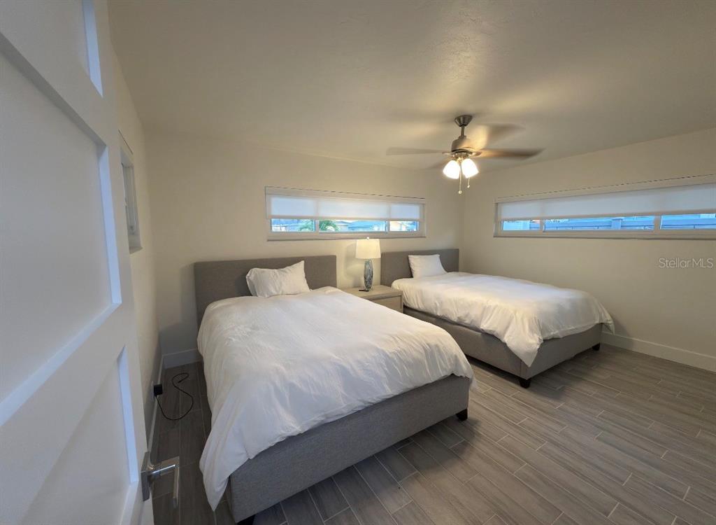 12350 4th Street East Treasure Island, FL 33706 - Photo 10 of 16 a bedroom with two beds and a chandelier