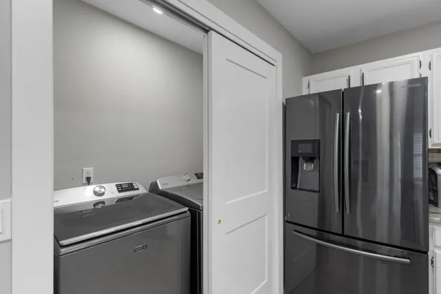a kitchen with metallic refrigerator freezer and a sink