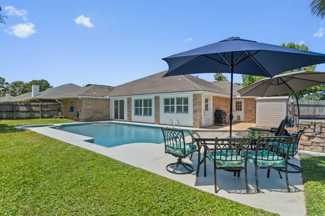 a view of a house with backyard sitting area and furniture