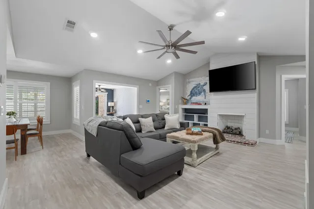 a living room with furniture a fireplace and a flat screen tv