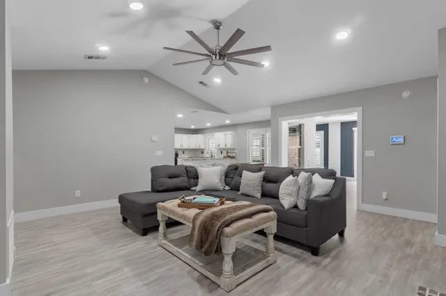 a living room with furniture and a ceiling fan