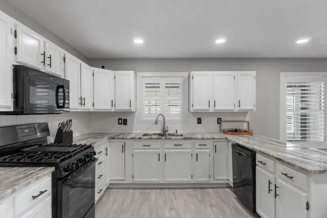 a kitchen with a sink stove top oven and cabinets