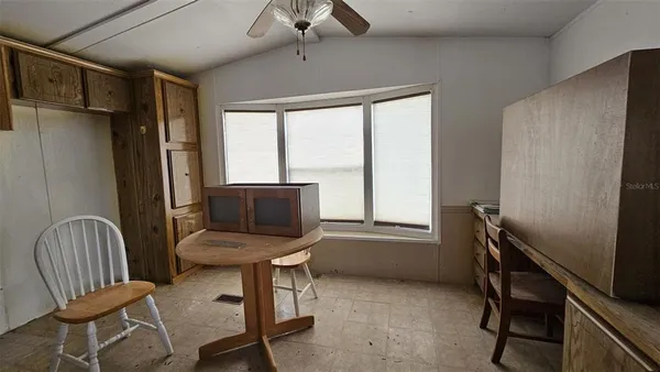 a view of a workspace with furniture and a window