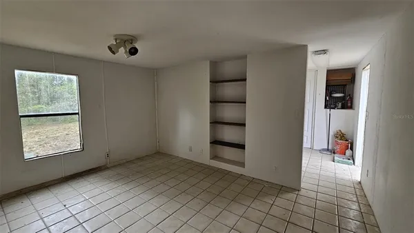 an empty room with windows and closet