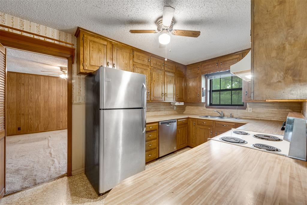 8798 Hill N Dale Road Tyler, TX 75709 - Photo 10 of 31 Kitchen featuring wood cabinetry, stainless steel refrigerator and dishwasher, electric range, and wood-finish countertops