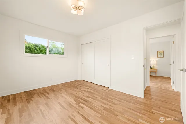 a view of a room with wooden floor and a window