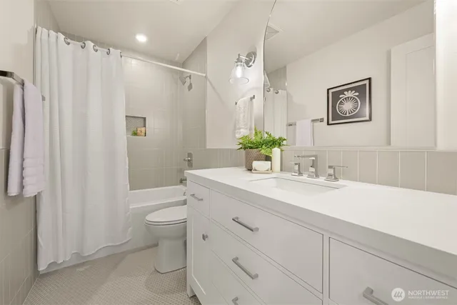 a bathroom with a granite countertop sink a toilet and a mirror
