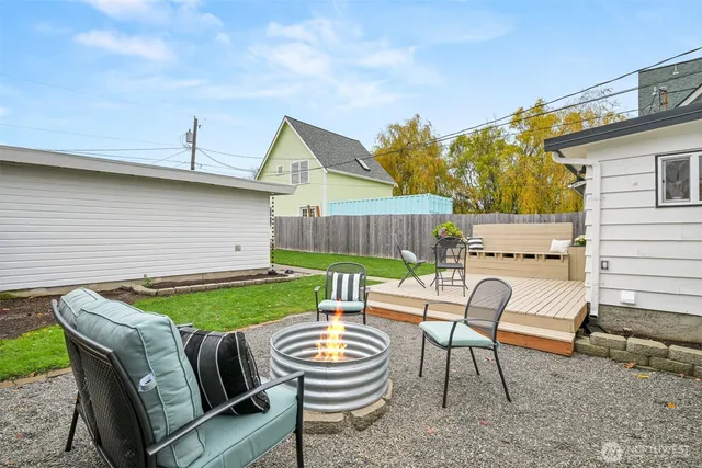 a view of a patio with table and chairs with wooden fence