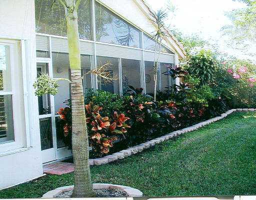 8901 Harrods Drive, Unit 9 Boca Raton, FL 33433 - Photo 4 of 6 a front view of a house with a yard and potted plants