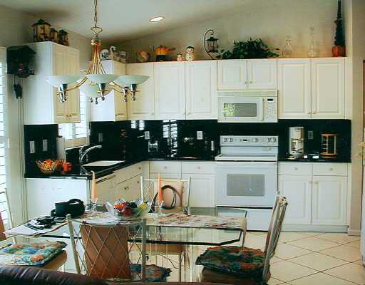 8901 Harrods Drive, Unit 9 Boca Raton, FL 33433 - Photo 6 of 6 a kitchen with stainless steel appliances granite countertop a stove a sink and white cabinets