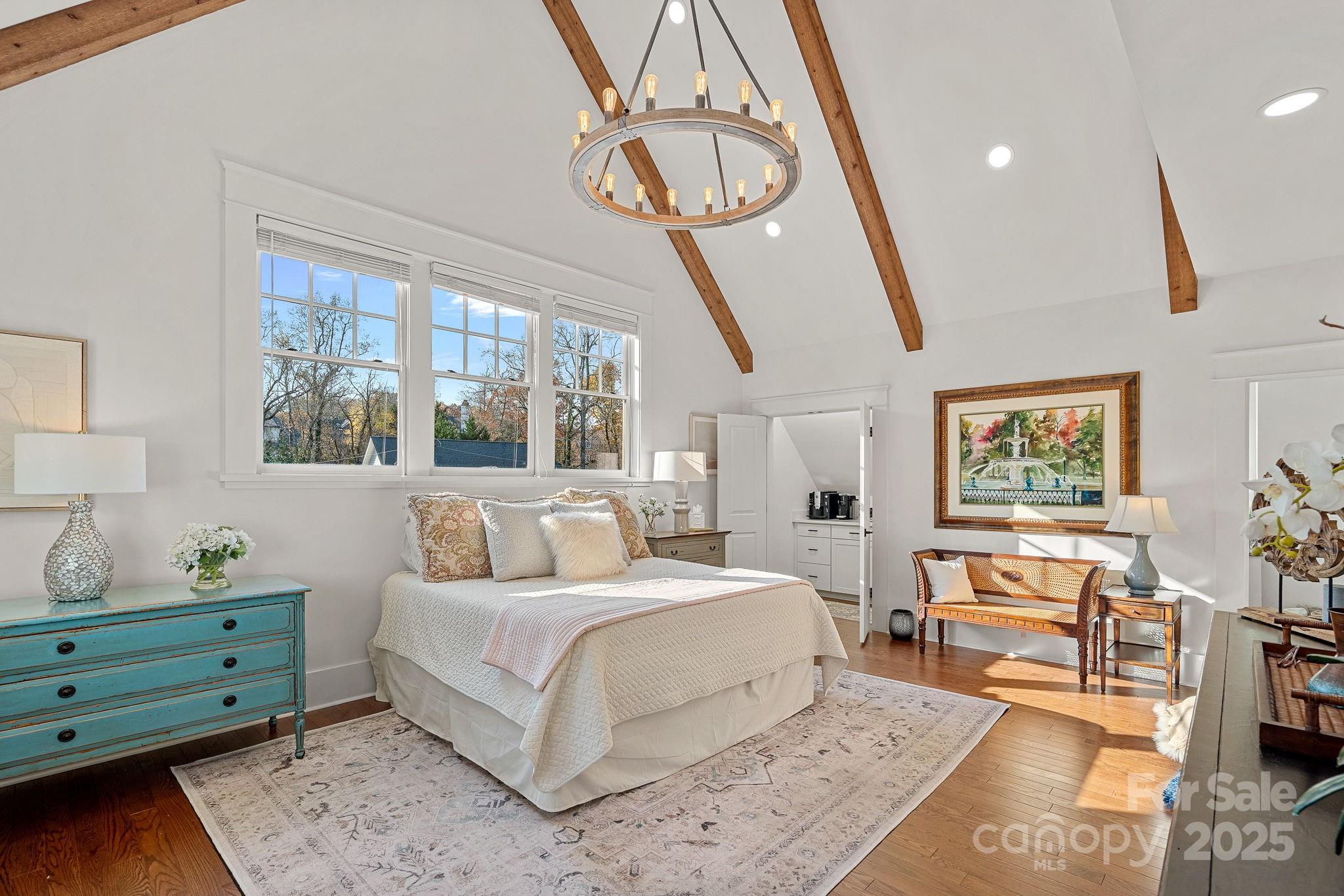 206 Meadowbrook Road Charlotte, NC 28211 - Photo 21 of 48 a bedroom with a bed a dresser and potted plants with the wooden floor