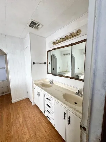 a bathroom with a granite countertop sink and mirror with bathtub