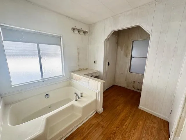 a bathroom with a tub sink and mirror
