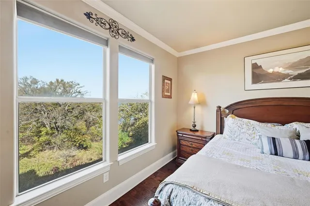 a bedroom with a bed wooden floor and window