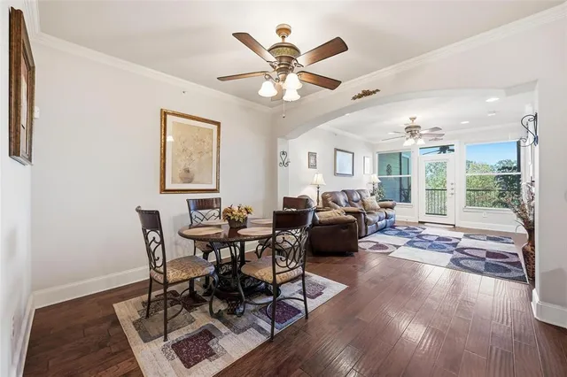 a living room with furniture a large window and wooden floor