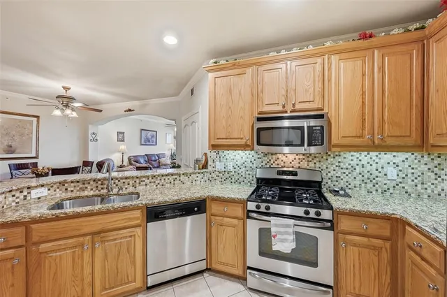 a kitchen with kitchen island granite countertop a sink stove and cabinets