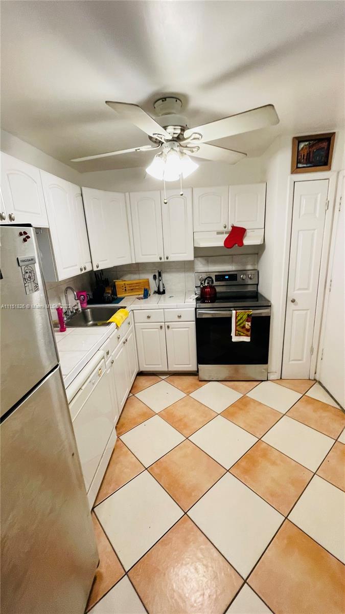 Second Forum Condominium North Miami Beach, FL 33179 - Photo 4 of 12 a kitchen with granite countertop a refrigerator and a stove top oven