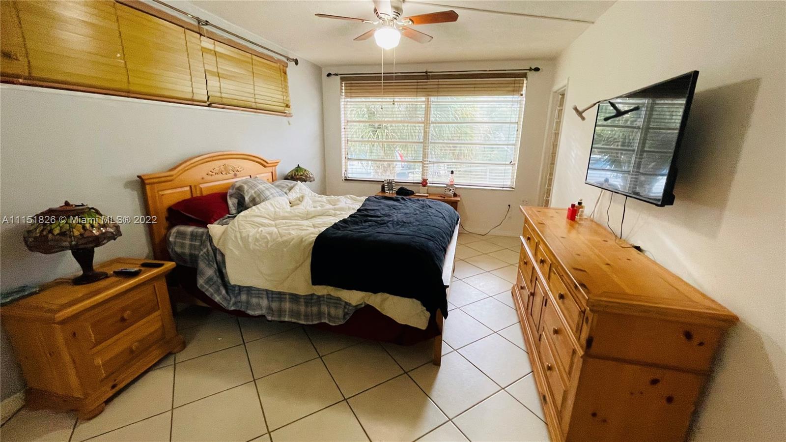 Second Forum Condominium North Miami Beach, FL 33179 - Photo 10 of 12 a bedroom with a bed and a flat tv screen on the dresser