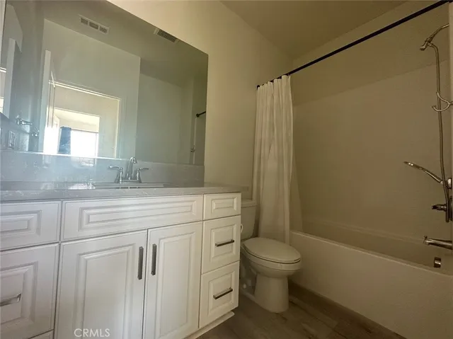 a bathroom with a granite countertop sink toilet a shower and a mirror